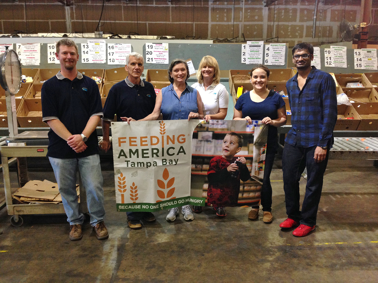 VIBE team members holding a banner for Feeding Tampa Bay