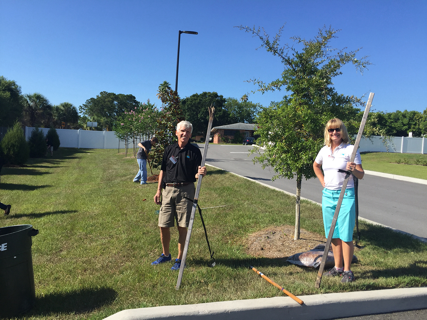 VIBE team members holding tree stakes at CASA